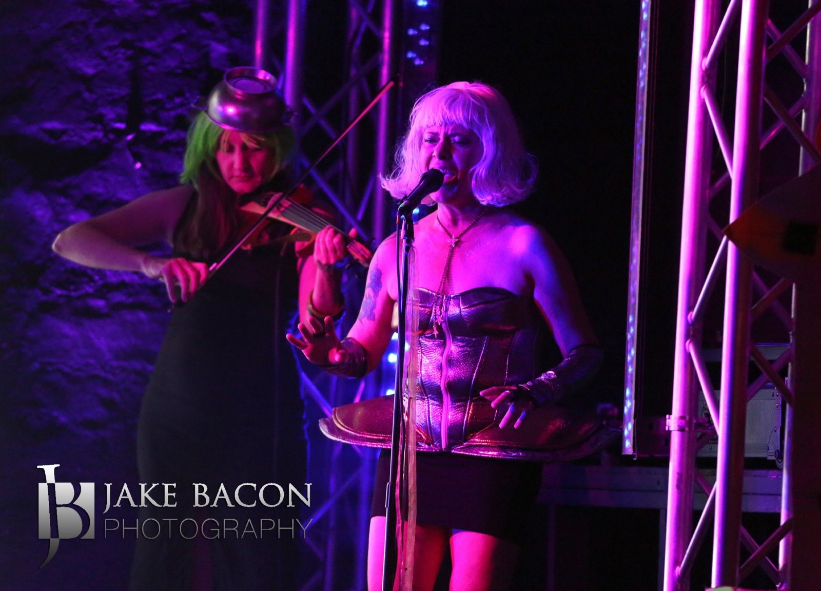 Violinist accompanying a white-wigged vocalist at stage right