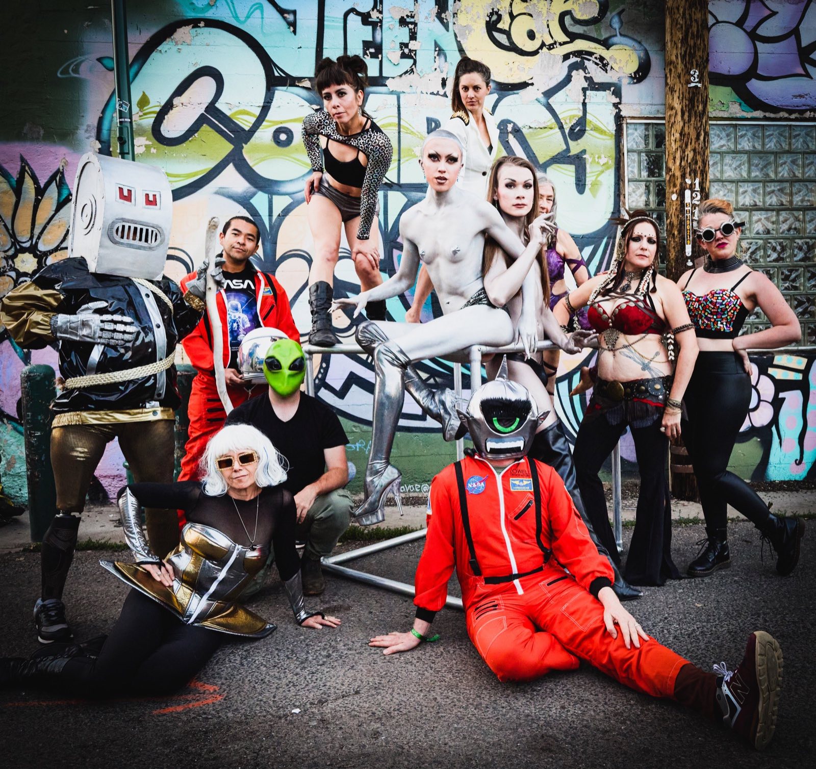 Full 2022 character ensemble arranged against the Green Room alley mural