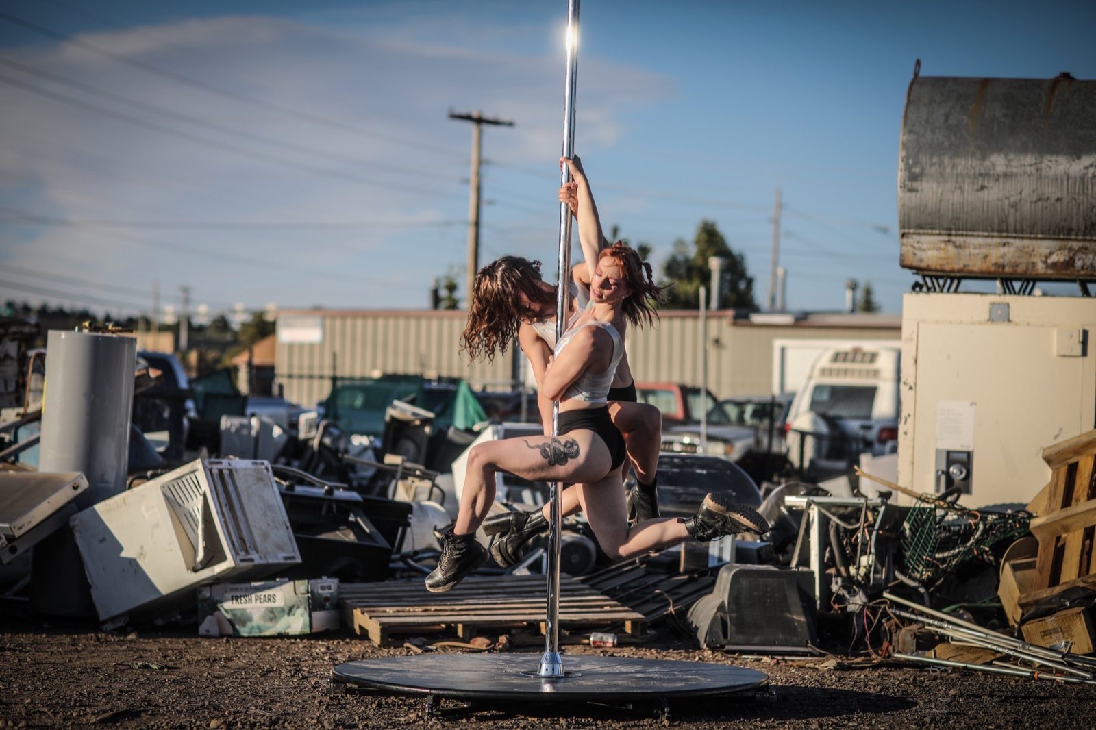 Performer posing with a hoop in a wide landscape of discarded equipment