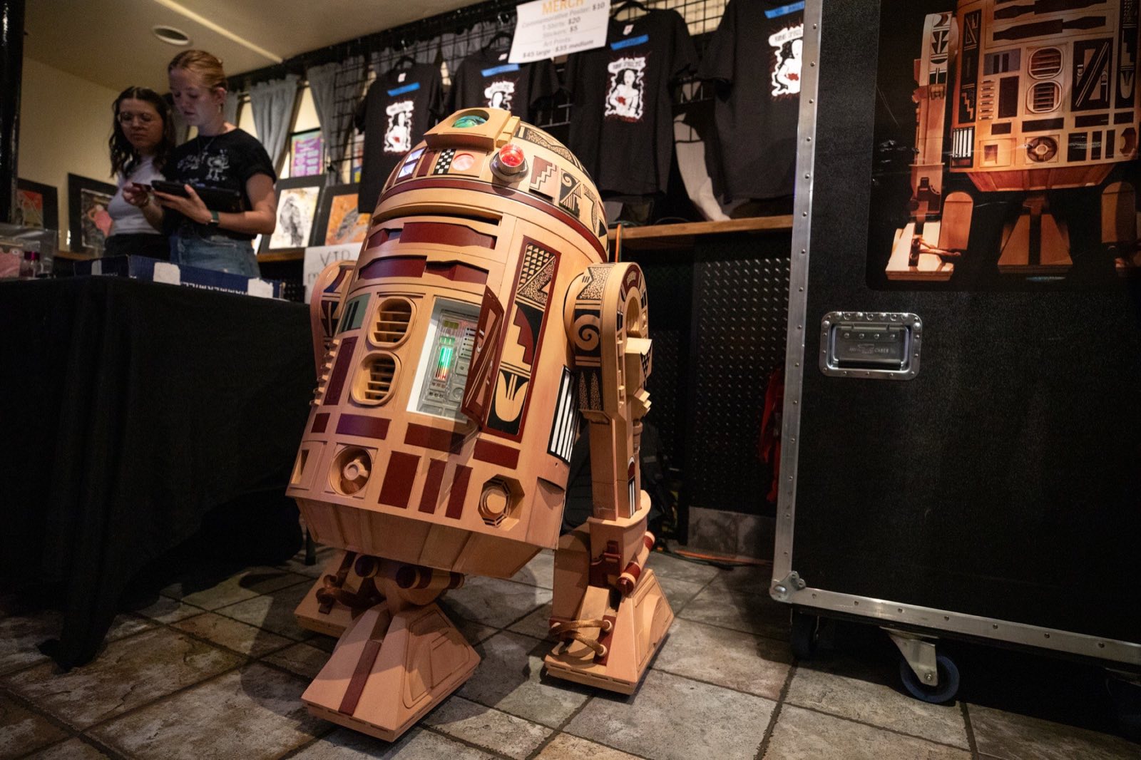 Handmade cardboard robot character waiting beside backstage equipment
