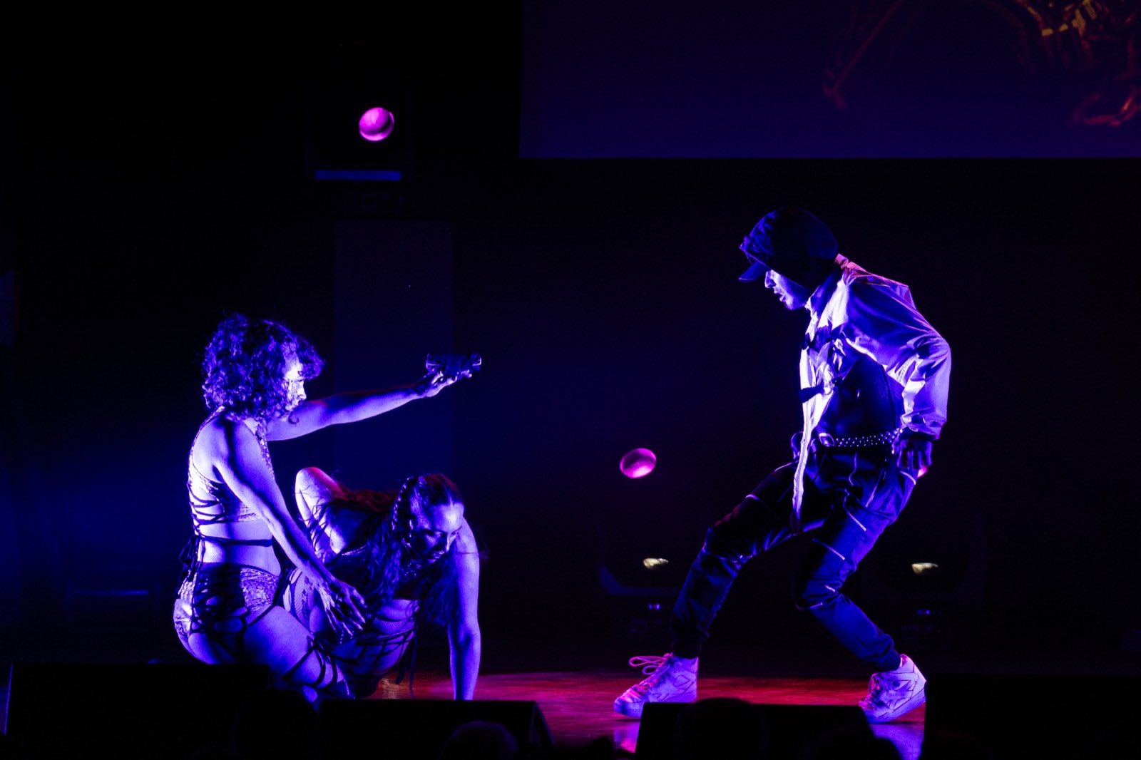 Two performers confronting one another during a blue-lit movement scene