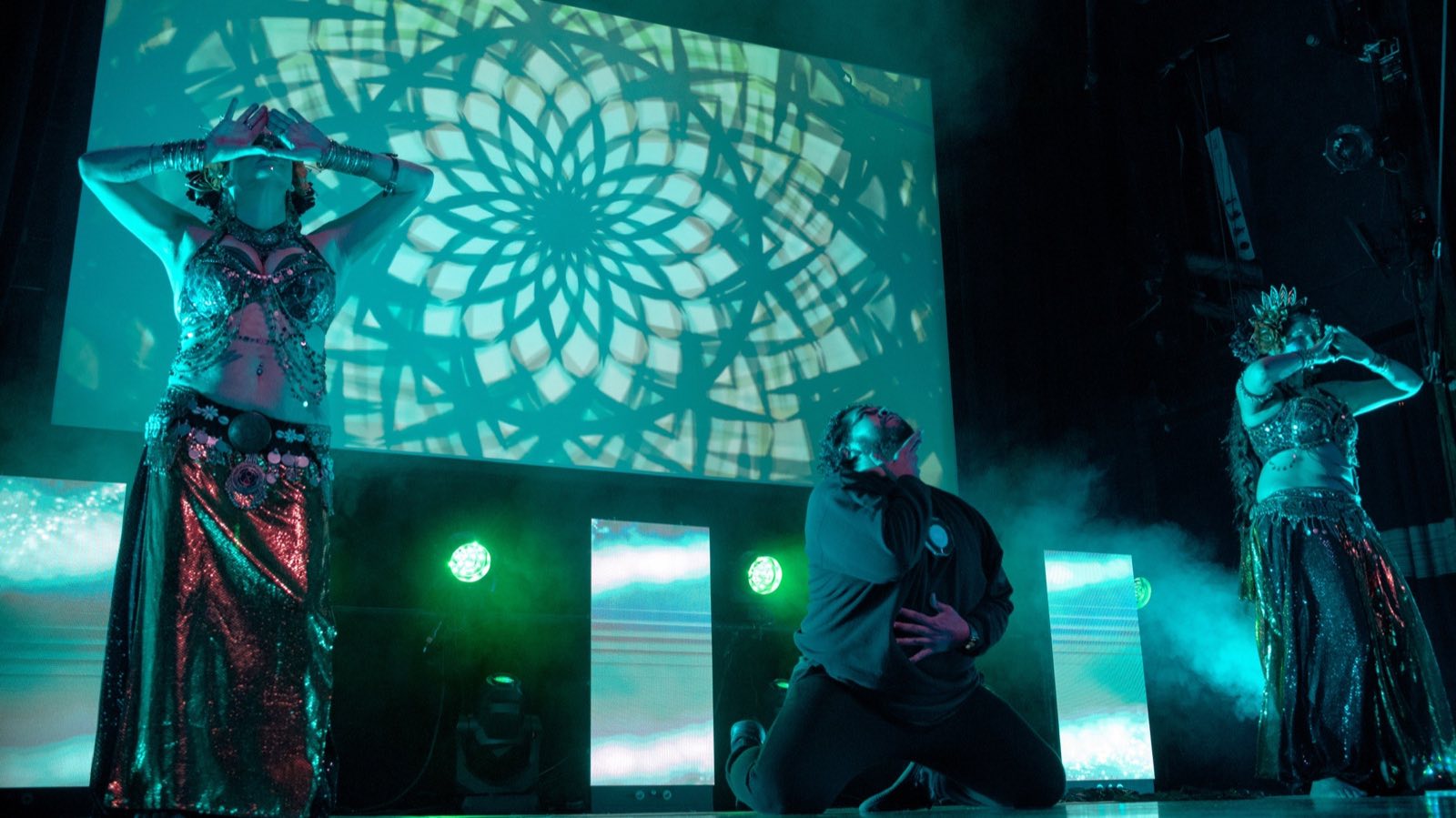 Live performers moving through a projected geometric world during Worlds and Wastelands