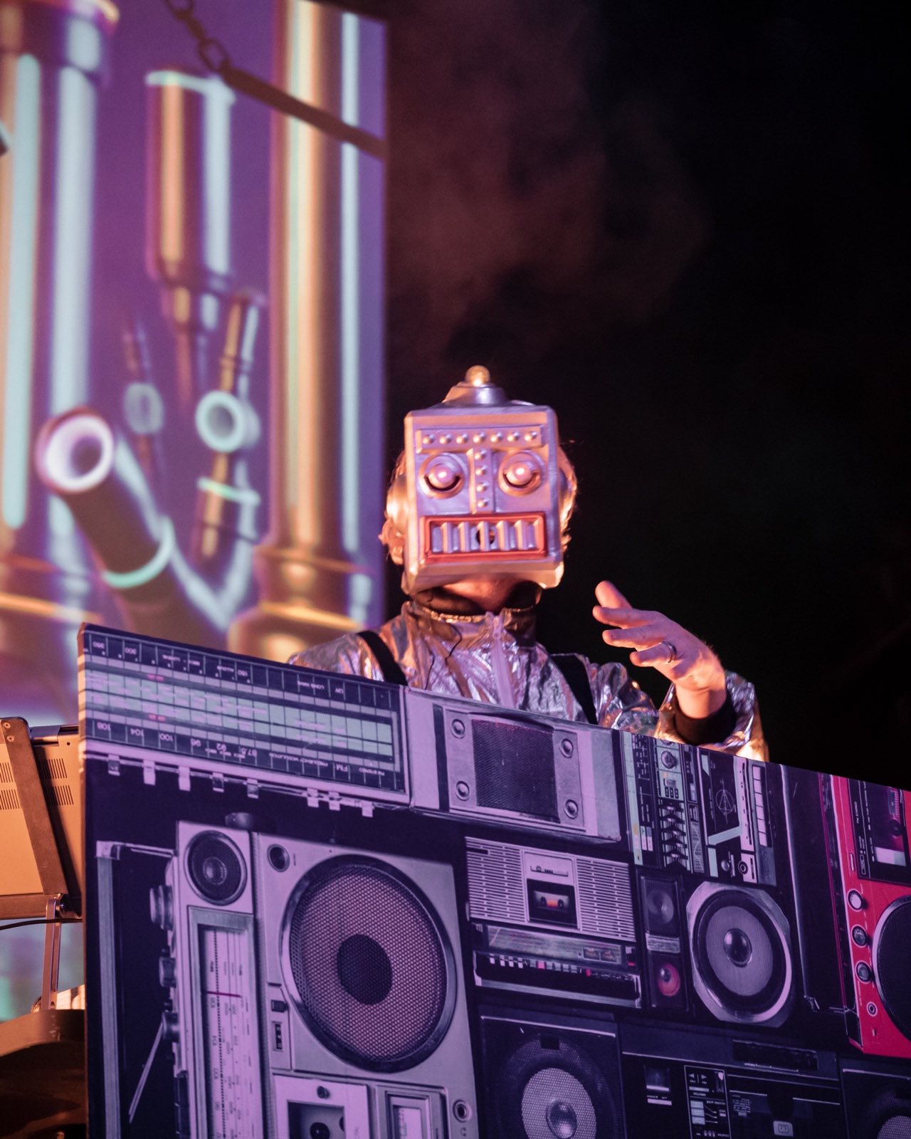 Box-headed robot DJ framed by projected controls