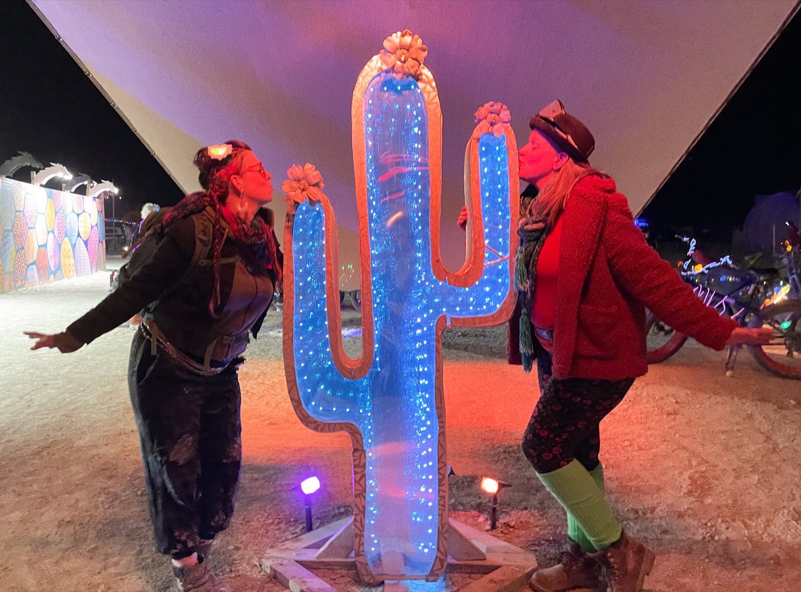 Kayley and Carlie standing with the illuminated Cosmic Cactus installation