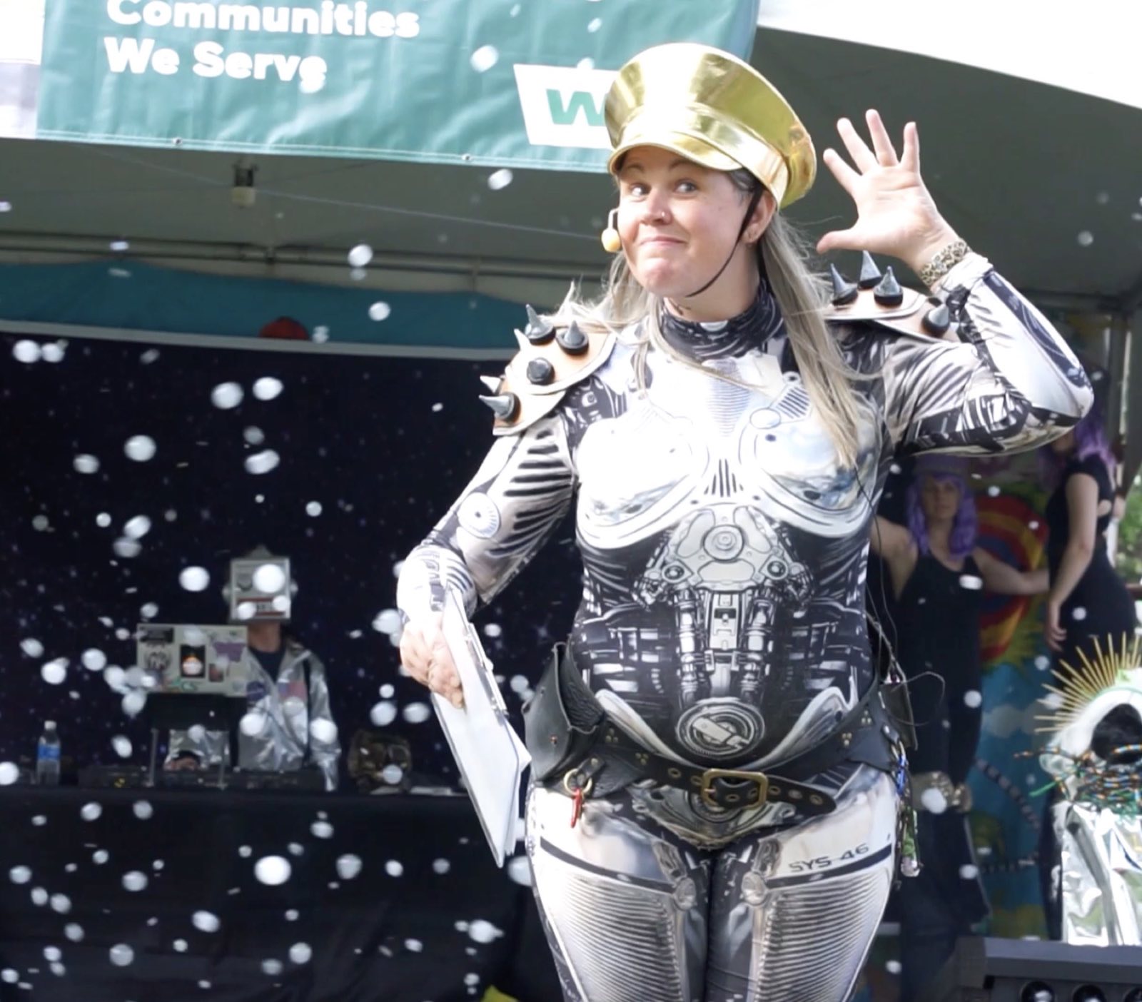 Robot character wearing a crown and metallic anatomical costume on the outdoor stage