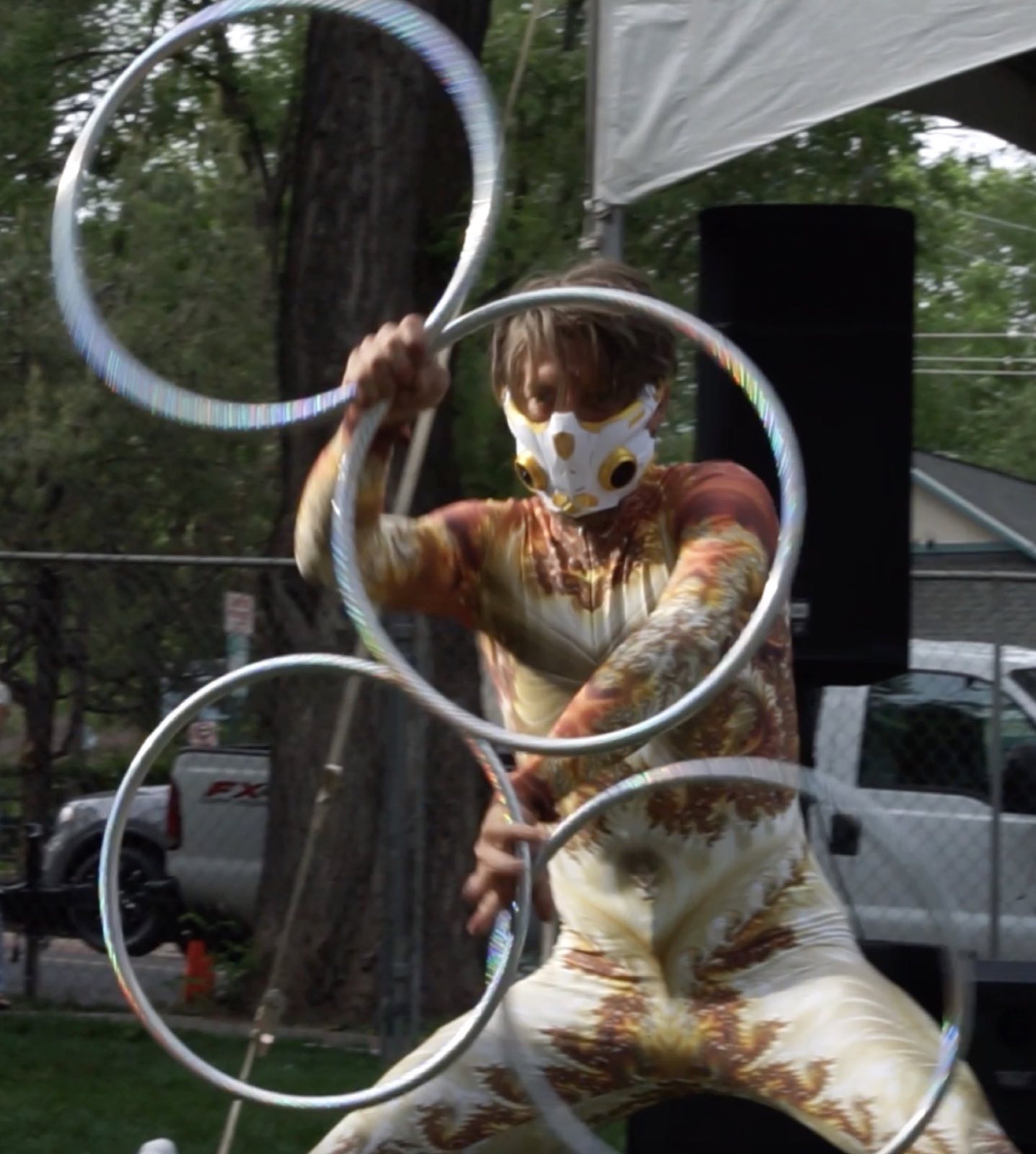 Performer framed by a vertical stack of silver hoops