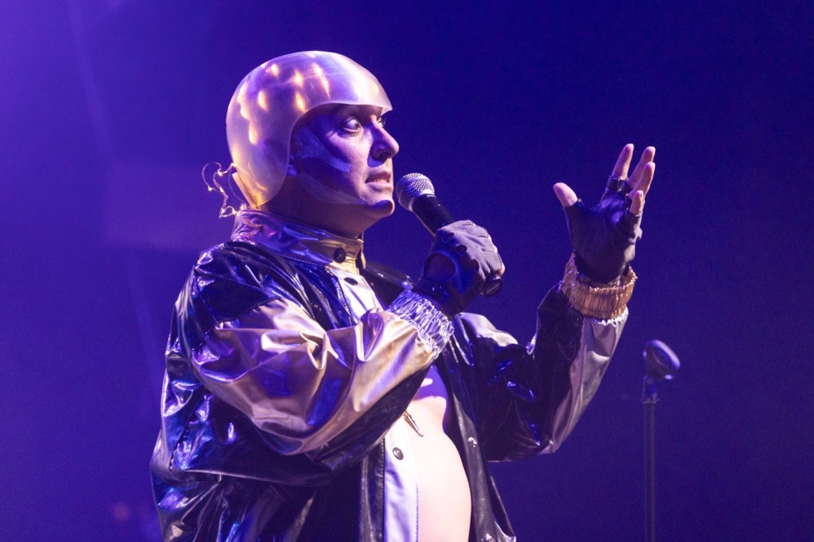 Android Dre narrating into a microphone under purple stage light