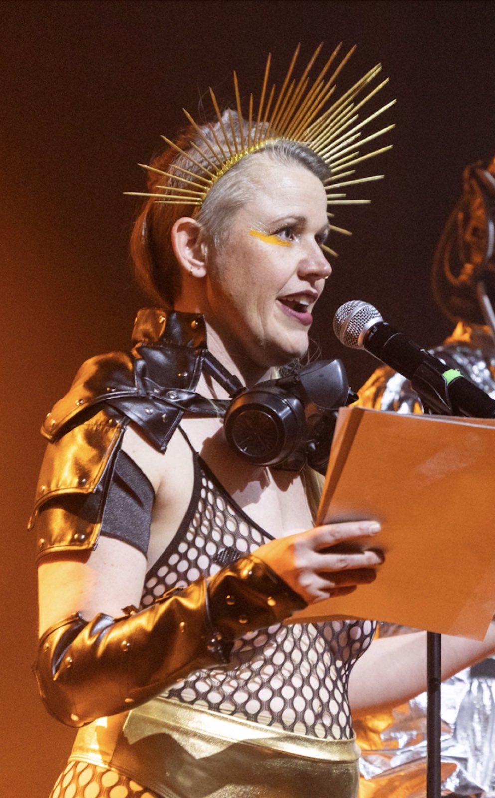 Kayley Quick speaking into a microphone in a metallic Robot Apocalypse costume